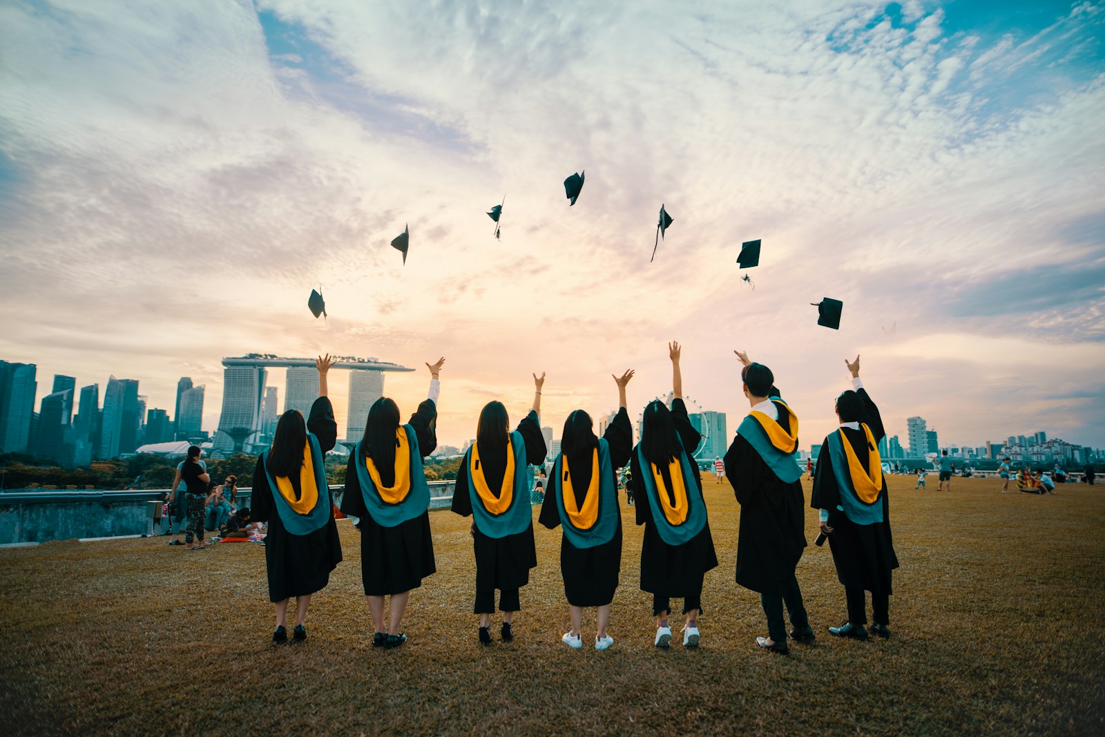 Graduates in gowns celebrating and throwing their mortarboards into the air